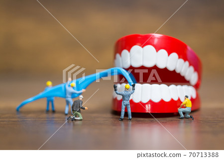Miniature people : Worker team repairing a tooth ,Healthcare and medical concept Miniature people : Worker team repairing a tooth ,Healthcare and medical concept 70713388