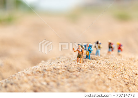 Miniature people : Traveler with backpack walking  on sand , Travel and Adventure concepts. 70714778