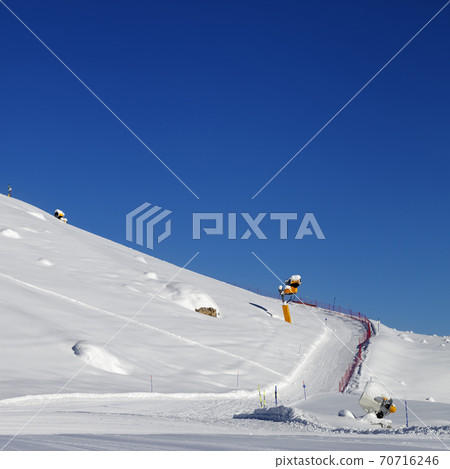 Ski slope with snowmaking at sun day Ski slope with snowmaking at sun day 70716246