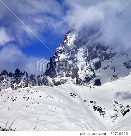 Mount Ushba in fog at sun winter day before storm Mount Ushba in fog at sun winter day before storm 70716250