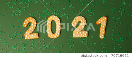Happy New Year's set of numbers 2021 from ginger biscuits glazed sugar icing decoration on natural shades of green background, minimal seasonal winter holiday card, banner, flyer, coupon Happy New Year's set of numbers 2021 from ginger biscuits glazed sugar icing decoration on natural shades of green background, minimal seasonal winter holiday card, banner, flyer, coupon 70716651