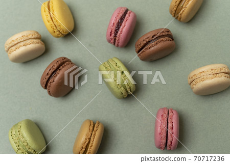 Colored tasty macaroons over a green background. 70717236