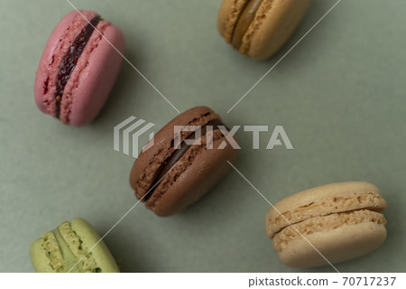 Colored tasty macaroons over a green background. Colored tasty macaroons over a green background. 70717237