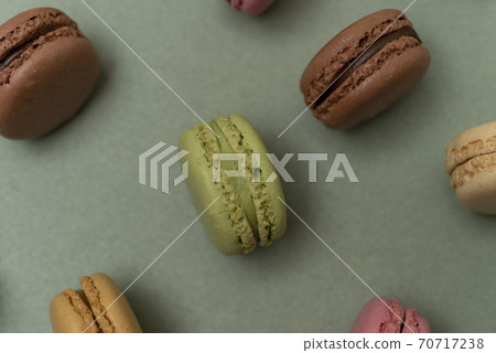 Colored tasty macaroons over a green background. Colored tasty macaroons over a green background. 70717238