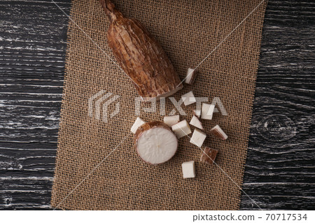 Sliced yucca root on a sackcloth on a black wooden table. Natural healthy ingredients Sliced yucca root on a sackcloth on a black wooden table. Natural healthy ingredients 70717534