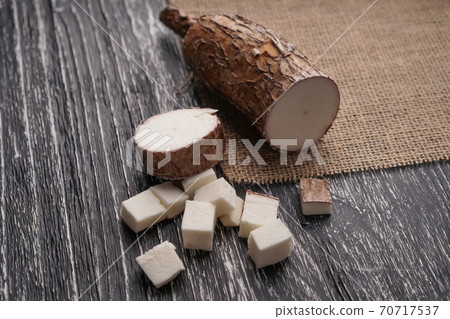 Sliced yucca root on a sackcloth on a black wooden table. Natural healthy ingredients 70717537