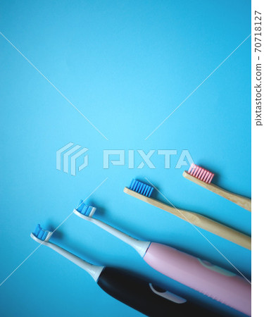 two ultrasonic electric toothbrushes on a blue background two ultrasonic electric toothbrushes on a blue background 70718127