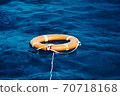 An Orange Lifebuoy Floating in the Middle of the Ocean 70718168