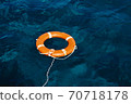 An Orange Lifebuoy Floating in the Middle of the Ocean 70718178