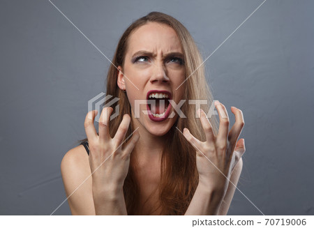 Photo of angry woman with bright make-up on grey background Photo of angry woman with bright make-up on grey background 70719006