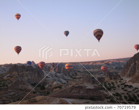 A colorful balloon floating in the sky of Cappadocia in the early morning 70719579