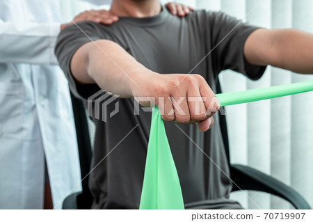 Female Physiotherapist working examining treating injured arm of athlete patient, stretching and exercise, Doing the therapy pain Rehabilitation in clinic Female Physiotherapist working examining treating injured arm of athlete patient, stretching and exercise, Doing the therapy pain Rehabilitation in clinic 70719907