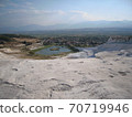 Pamukkale's white lime shelves and distant cityscape 70719946