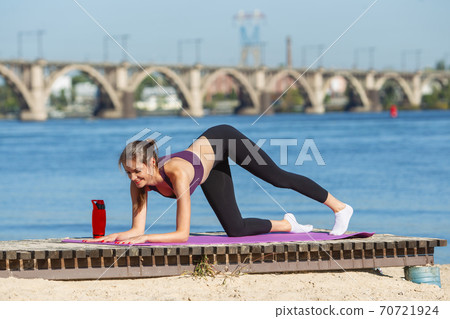 Young woman training outdoors in autumn sunshine. Concept of sport, healthy lifestyle, movement, activity. 70721924