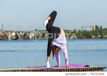 Young woman training outdoors in autumn sunshine. Concept of sport, healthy lifestyle, movement, activity. 70721940