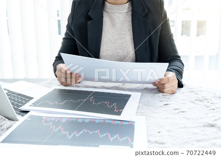 The hands of a female business brokerage are planning business investments by analyzing and calculating the stock market to find market profits The hands of a female business brokerage are planning business investments by analyzing and calculating the stock market to find market profits 70722449