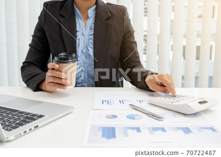 The hands of a male businesswoman use the calculator are analyzing and calculating the annual income and expenses in a financial graph that shows results To summarize balances overall in office The hands of a male businesswoman use the calculator are analyzing and calculating the annual income and expenses in a financial graph that shows results To summarize balances overall in office 70722487