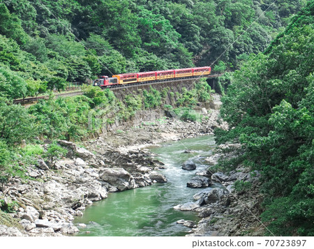 Hozukyo and trolley trains with beautiful greenery on hot summer days seen from Hozukyo Station on the Sagano Sanin Line 70723897