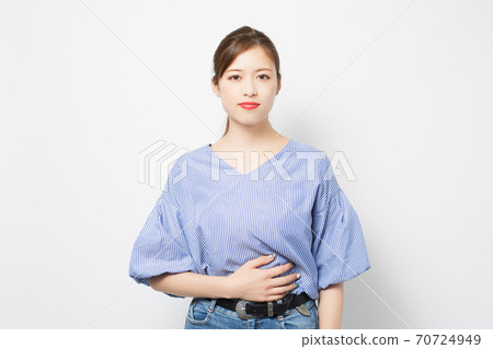 Young woman putting her hand on her stomach 70724949
