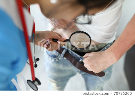 Doctor with magnifying glass looks at man's crotch. Doctor with magnifying glass looks at man's crotch. 70725260