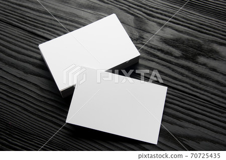 Business card blank on black wooden background. Corporate Stationery, Branding Mock-up. Creative designer desk. Flat lay. Copy space for text 70725435