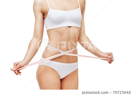 Slim tanned woman's body isolated on white background - waist measurement 70725648