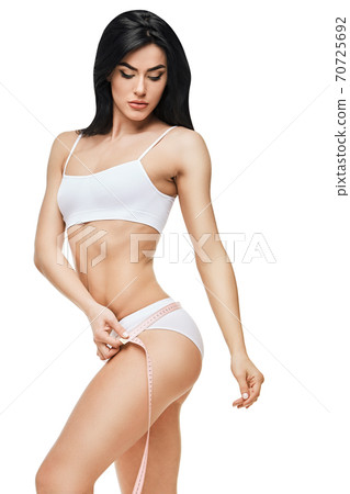 Slim tanned woman's body isolated on white background - waist measurement 70725692