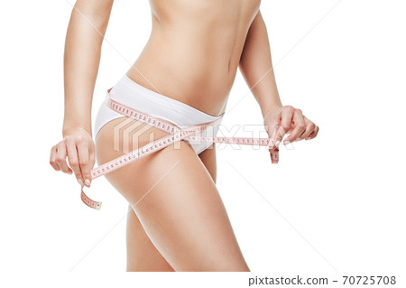 Slim tanned woman's body isolated on white background - waist measurement 70725708
