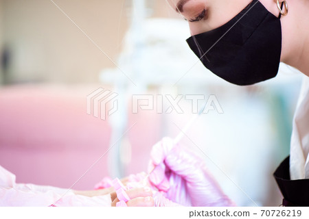 Pedicure in beauty salon. Nail polishing with nail polish. Close up. 70726219