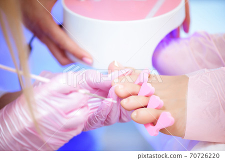 Pedicure in beauty salon. Nail polishing with nail polish. Close up. Pedicure in beauty salon. Nail polishing with nail polish. Close up. 70726220