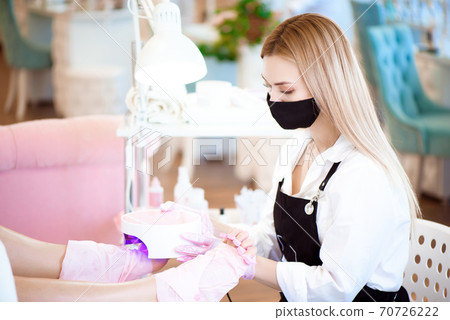 Specialist with client in beauty salon. Professional beauty service. Pedicure, manicure concept. Comfortable armchair. 70726222