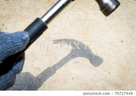 Hand with glove holding hammer Hand with glove holding hammer 70727448