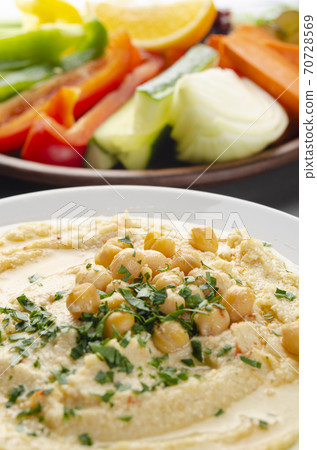 Low angle view at vegetable Hummus dip dish topped with chickpeas and olive oil Low angle view at vegetable Hummus dip dish topped with chickpeas and olive oil 70728569