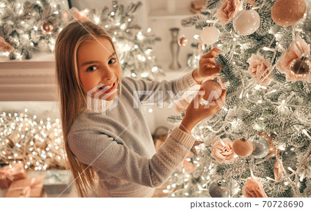 The cute girl decorating the christmas tree The cute girl decorating the christmas tree 70728690