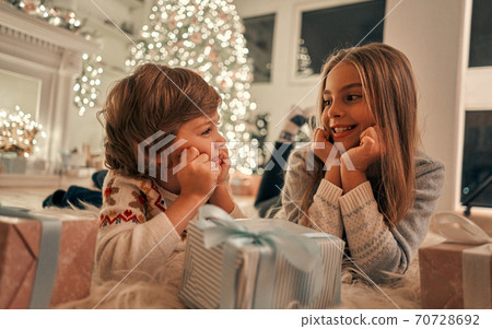 The happy girl and boy with gifts laying on the floor The happy girl and boy with gifts laying on the floor 70728692