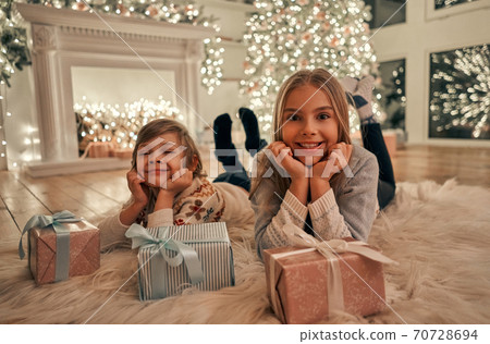 The happy girl and boy with gifts laying on the floor The happy girl and boy with gifts laying on the floor 70728694
