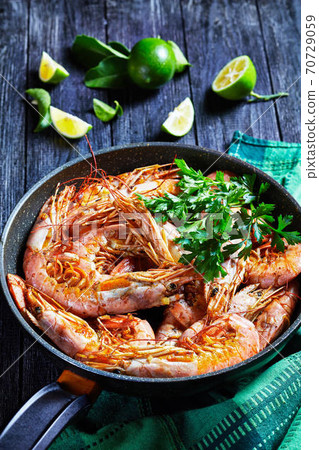 Garlic butter shrimps cooked on a skillet Garlic butter shrimps cooked on a skillet 70729059