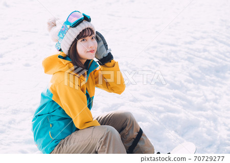 Young woman snowboarding (snowboarding) 70729277