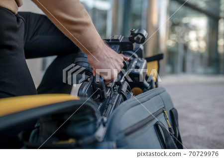 Close-up of male hands taking camera out of the case 70729976