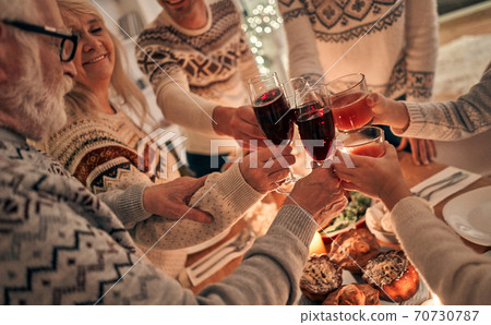The happy family clink glasses above the christmas table The happy family clink glasses above the christmas table 70730787