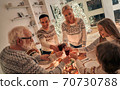 The happy family clink glasses above the christmas table 70730788