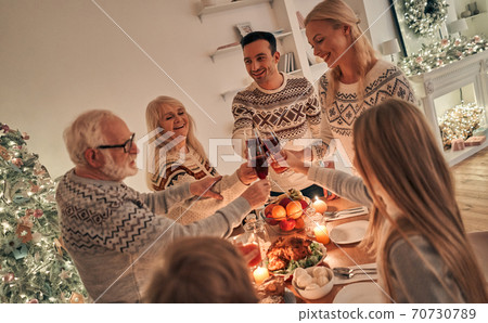The happy family clinking glasses above the christmas table 70730789