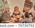 The man fills wine glasses above the festive table 70730792