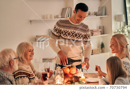 The happy man fills wine glasses above the festive table The happy man fills wine glasses above the festive table 70730794