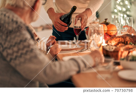 The man fills a glass above the table The man fills a glass above the table 70730798