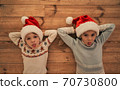 The kids in red hats laying on the floor 70730800
