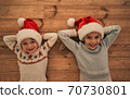 The happy kids in red hats laying on the floor 70730801