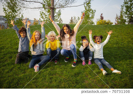 Interracial group of kids, girls and boys playing together at the park in summer day Interracial group of kids, girls and boys playing together at the park in summer day 70731108