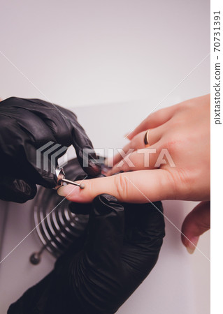 woman doing manicure in a beauty salon. Close-up of hands. 70731391
