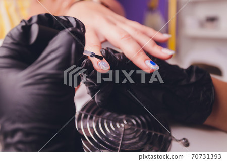 woman doing manicure in a beauty salon. Close-up of hands. 70731393